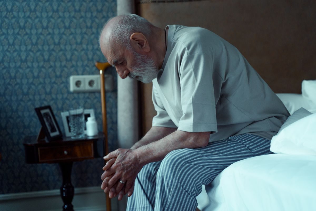 A man lying awake in bed at night, unable to sleep