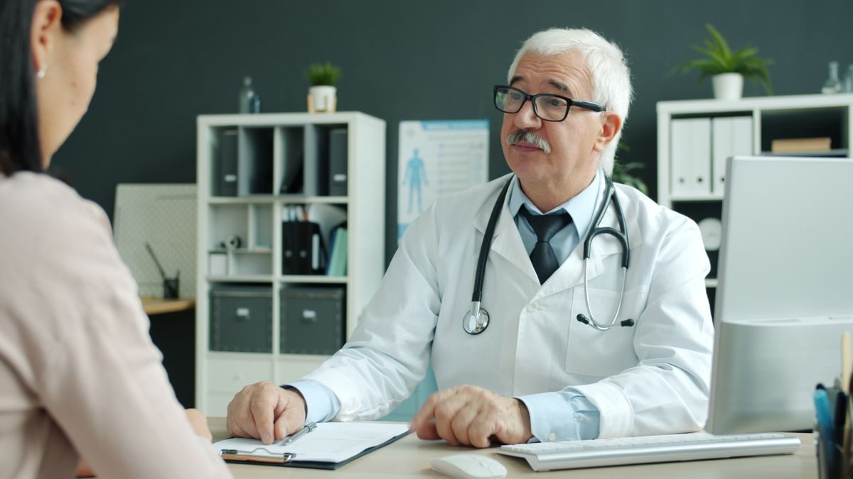 A doctor consulting with a patient in an exam room