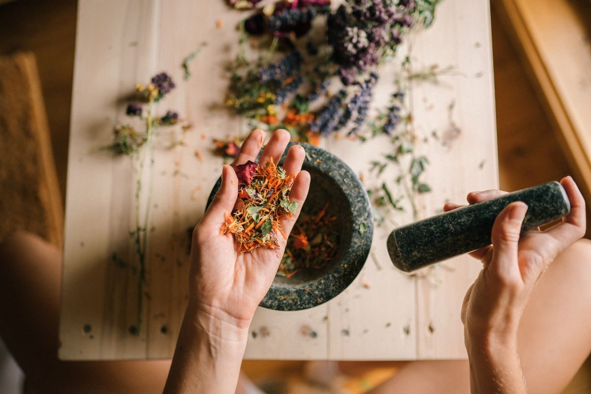Chinese herbs being ground in a mortar and pestle